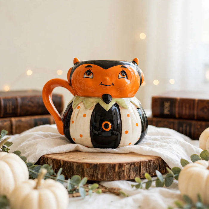 Devil Mug by Johanna Parker Design for Transpac styled with cream pumpkins, eucalyptus and vintage books