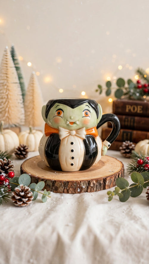 Dracula Mug by Johanna Parker Design for Transpac styled with winter greenery and bottle brush trees